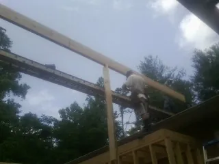 Carpenter setting a ridge beam over a new addition frame — Ice Dam Removal by Roofing Brothers in Sedley