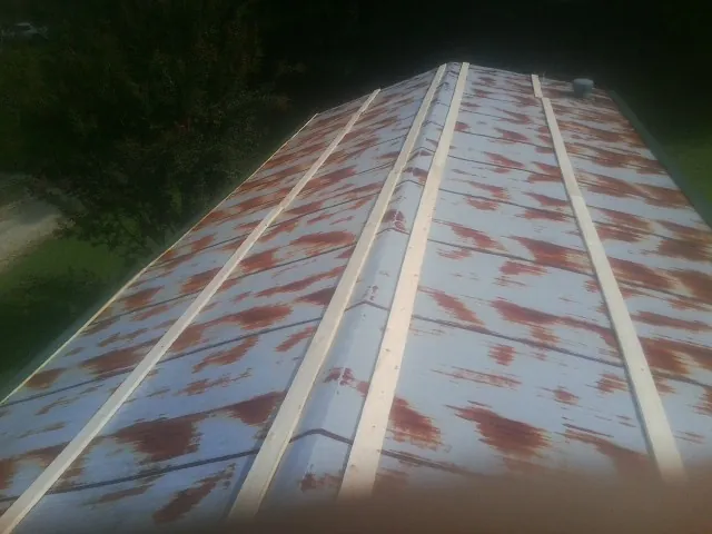 Rusted metal roof panels with new wood purlins before replacement — Storm Damage Roof Repair in Sedley by Roofing Brothers