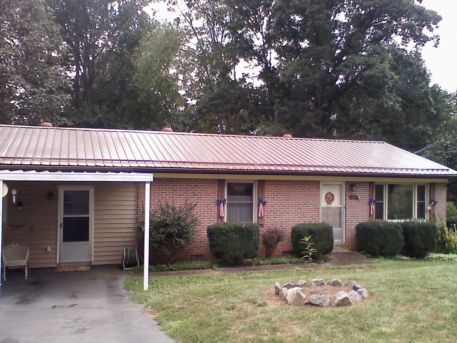 Bronze metal roof and carport on a brick ranch home — Roof Repair work by our crew in Sedley